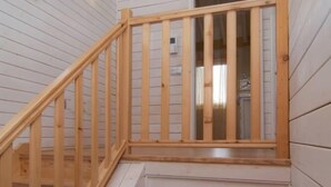 A wooden staircase leading to a second-floor landing with a small window.
