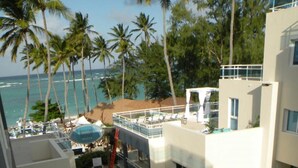 Ein Hotel mit Poolbereich, Palmen und Meerblick.
