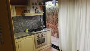 Eine Küche mit Gasherd, Backofen und Arbeitsplatte aus Granit.