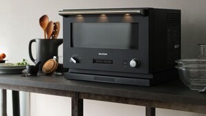 A kitchen with a black countertop, a coffee maker, a kettle, and wooden utensils. - House Kira (Chatan)