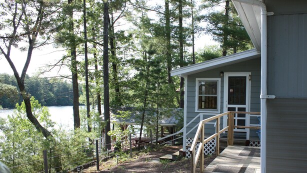 Une cabane dotée d’une terrasse en bois et d’un escalier menant à un porche.