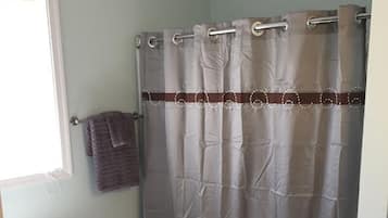 A bathroom with a white toilet, a shower curtain, and a towel rack.