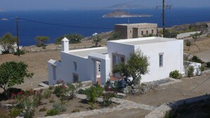 A white building with a small garden and a view of the sea. - Chora villa 1 with unique sea view (Hora)