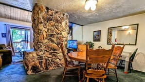 Ein gemütliches Zimmer mit Steinwand, einem runden Holztisch und Stühlen.
