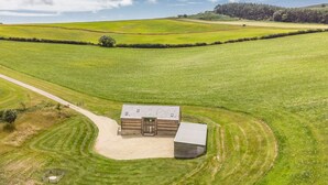 A rural property with a main building, a smaller structure, and a fenced area.