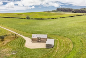 A rural property with a main building, a smaller structure, and a fenced area.