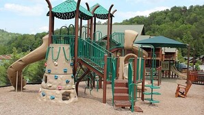 A playground with climbing structures, slides, and a covered seating area.