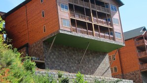 A multi-story wooden building with balconies and a stone base.