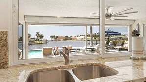 Una cocina con un amplio ventanal que da a una piscina y zona de resort.