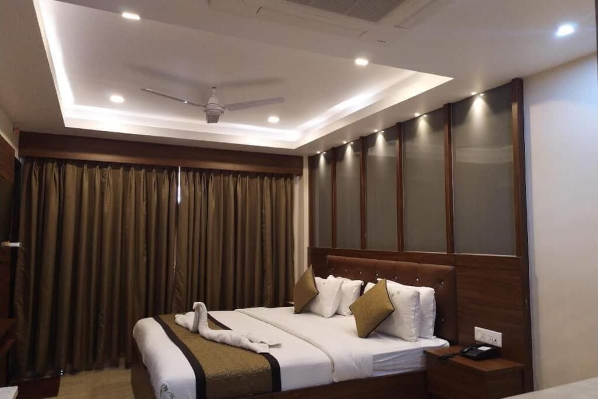 A hotel room with a bed, bedside table, and a ceiling fan.