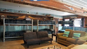 Una habitación rústica con literas, un sofá y un sillón.