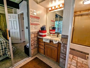 Une salle de bain équipée d’un miroir, d’un lavabo et d’un panneau d’avertissement à l’attention des utilisateurs du spa.