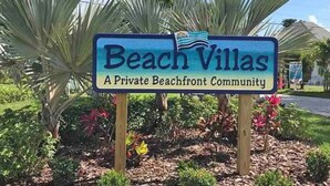 Skilt for 'Beach Villas', der angiver et privat strandmiljø.