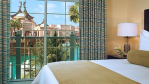 Habitación de hotel con una cama grande, vistas a un edificio con cúpulas y un balcón con barandilla.