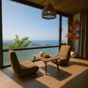 A room with a view of the sea, a table with a teapot, two chairs, and a hanging light fixture. - Twilight House (New Taipei City)