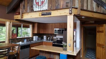 A kitchen with wooden cabinets, a microwave, a dishwasher, and a sign indicating 'Heavenly Valley' and 'Lake Tahoe'.