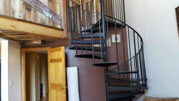 A spiral staircase with a wooden door leading to a room.