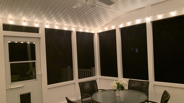 A covered patio with a round table and chairs, large windows, and string lights. - Clean, Spacious Family House (Annapolis)