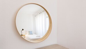 A round mirror on a wall above a wooden bench. - CASAS DA PRAIA JOANA (Almancil)