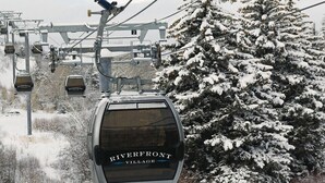 A snow-covered landscape with a ski lift and a sign for Riverfront Village. - Awesome Two-Bedroom Villa - New Year’s Week - Sheraton Mountain Vista (Avon)