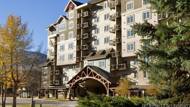 A multi-story hotel with balconies, a covered entrance, and a mountainous backdrop. - Awesome Two-Bedroom Villa - New Year’s Week - Sheraton Mountain Vista (Avon)