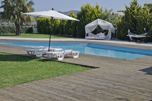 A pool area with a wooden deck, white lounge chairs, a canopy, and a tent. - ktima reveli luxury villa (χανια καλαθας)