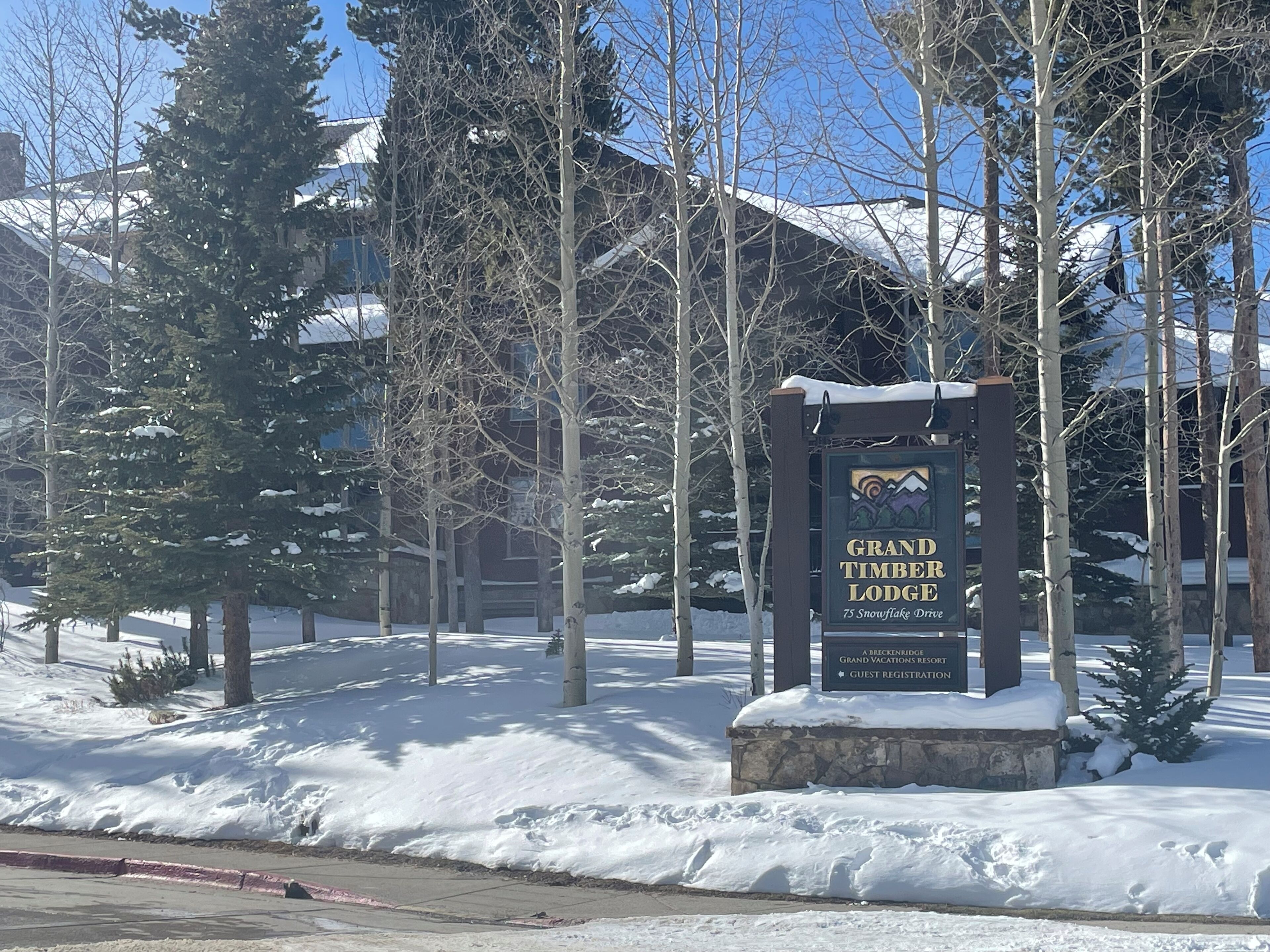 Une enseigne pour le Grand Timber Lodge, avec une montagne en arrière-plan.