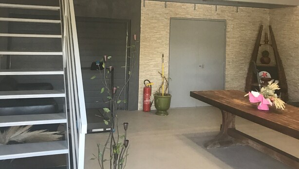 Een modern interieur met een trap, een open haard en een bankje.