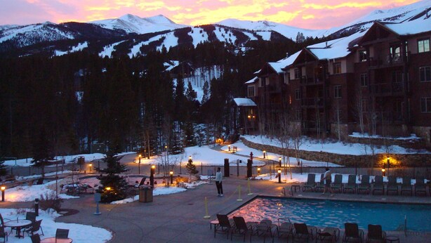 A resort with a pool, outdoor seating, and a mountain backdrop. - One Bedroom Master Unit. Beautiful Luxury Ski in, Ski Out Resort (Breckenridge)