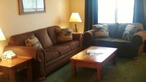 A living room with two sofas, a coffee table, and lamps. - 2br Condo Re-modeled Great Smokey Mountains Dollywood Old Mill July 4th (Pigeon Forge)