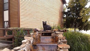 A bear statue on a stone waterfall structure with a wooden building in the background. - 2br Condo Re-modeled Great Smokey Mountains Dollywood Old Mill July 4th (Pigeon Forge)