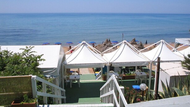 Ein Restaurant direkt am Strand mit Außenbereich und Meerblick.