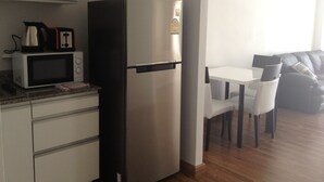 A compact kitchen with a refrigerator, microwave, and a small coffee maker on the countertop. - Nice 1- Bedroom Condo In Klong Muang (Klong Muang)