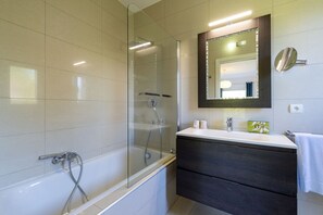 A modern bathroom with a glass-enclosed shower, a white bathtub, a dark wooden vanity, and a large mirror. - Master Suite Villa featuring a Private Pool, Garden, Parking and Spa (CALVI)