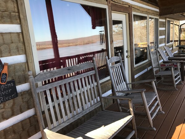 A wooden deck with benches and a view of a river.