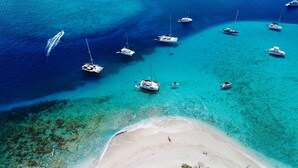 An aerial view of a beach with clear turquoise waters, several boats anchored, and a sandy shore with a few people. - Magens Bay Super Villa! 2024 Specials - 1or2 Nts Free 3Pools - Beach -36' Boat! (St. Thomas)