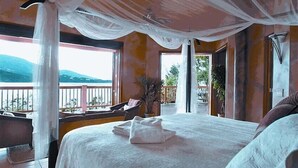 A bedroom with a large bed, a balcony with a view, and a ceiling with draped fabric. - Magens Bay Super Villa! 2024 Specials - 1or2 Nts Free 3Pools - Beach -36' Boat! (St. Thomas)