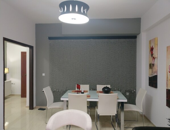 Un espace repas comprenant une table, des chaises et un luminaire moderne.