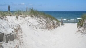 A sandy beach path leading to the ocean with a clear sky. - Charming 18th century cottage with its own beachfront on Scargo Lake near bay (Dennis)