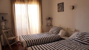 A bedroom with two beds, a desk, and a chair. - Two bedroom apartment with sea views (Ampuriabrava)