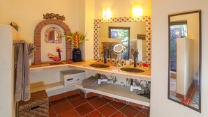 Un baño con dos lavamanos, un espejo y un arco decorativo.