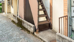 A narrow alleyway with a staircase leading to a building entrance.