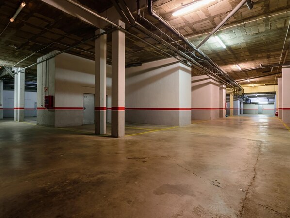 An indoor parking garage with concrete pillars, red safety lines, and a clean, well-lit environment. - Costabravaforrent Segalar 9 (Albons)