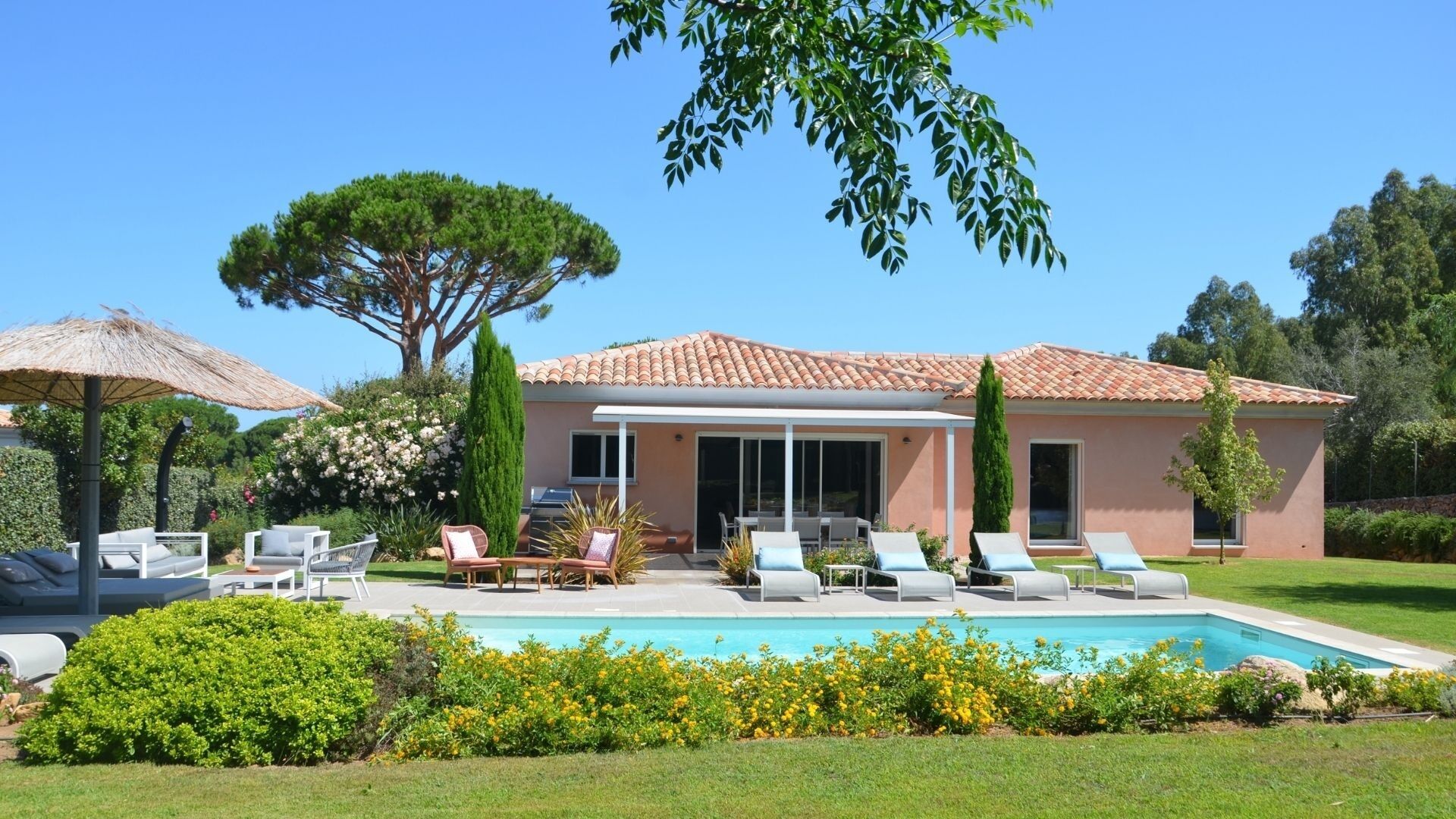 A house with a swimming pool, outdoor seating, and a garden.