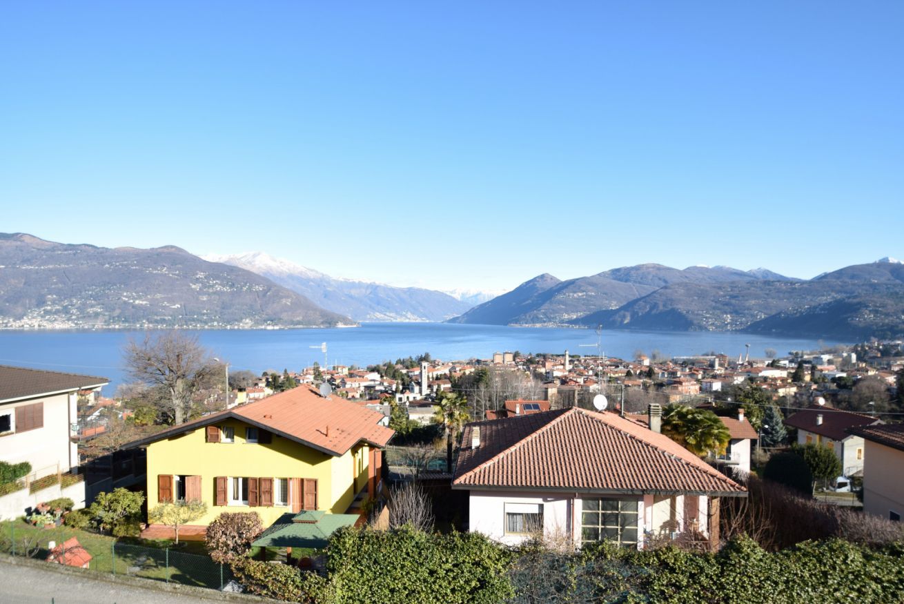 A residential area with houses, a lake, and mountains in the background.
