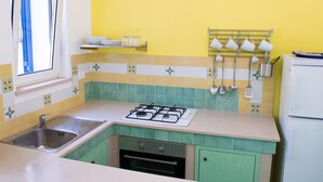 Eine Küche mit Gasherd, Spüle und Kühlschrank.