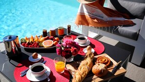 A breakfast tray with fruits, pastries, and beverages by a poolside. - Master  Suite Villa featuring a Private Pool, Garden, Parking and Spa (Calvi)