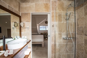 Un baño moderno con un lavamanos blanco grande, un espejo y una ducha.