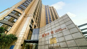 Un immeuble de grande hauteur doté d’une entrée imposante et d’une enseigne indiquant qu’il s’agit d’un hôtel.