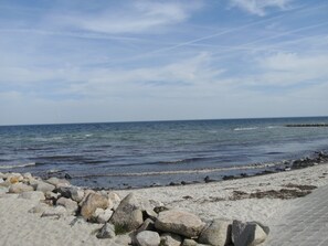 A beach with a rocky shoreline and a clear view of the ocean.